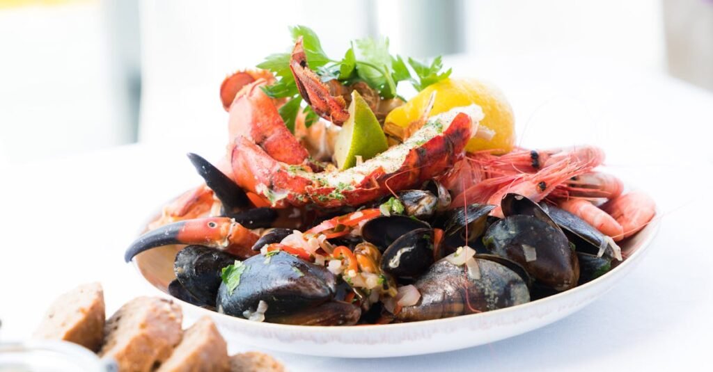 A vibrant seafood platter featuring lobster, shrimp, mussels, and lemon on a white plate.